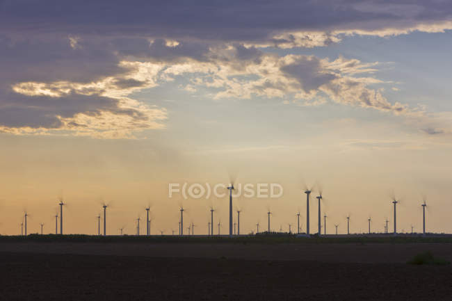 Parque eólico al atardecer bajo el cielo nublado, Roscoe, Texas, EE.UU. - foto de stock
