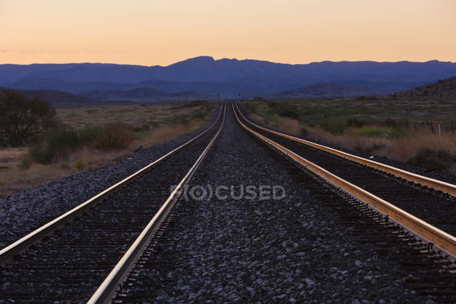 Linhas ferroviárias ao amanhecer com montanhas à distância, Texas, EUA — Fotografia de Stock