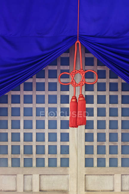 Fabric with knots on cord hanging in front of lattice door, Ise, Japan — Stock Photo