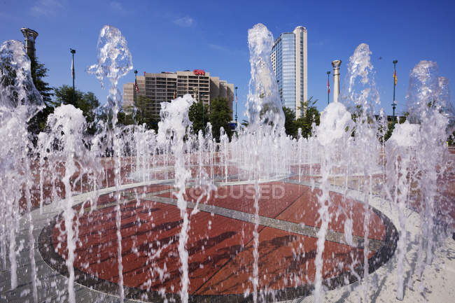 Фонтан в Олімпійському парку з міською будівлями в далечині, Атланта, штат Джорджія, США — стокове фото