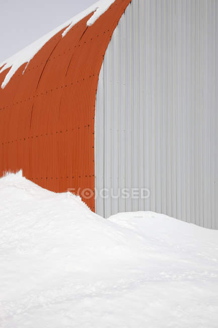 Белый и оранжевый сарай в снегу на Хоккайдо, Япония — стоковое фото