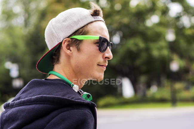 Caucasian man wearing sunglasses and headphones in park — Stock Photo