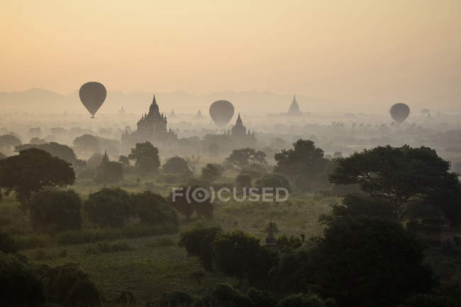 Воздушные шары, летящие над древними башнями ступы в Янгоне, Мьянме, Азии — стоковое фото