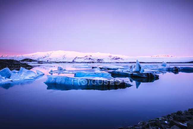 Icebergs geleira flutuando na água do lago remoto ao nascer do sol na Islândia — Fotografia de Stock