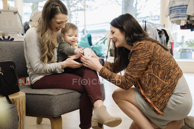 Donne caucasiche e baby boy shopping nel negozio di scarpe — Foto stock