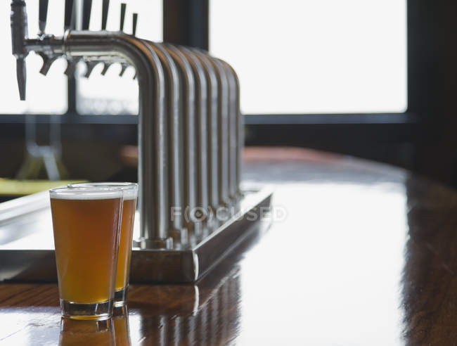Close-up of pints of beer on empty bar counter — Stock Photo