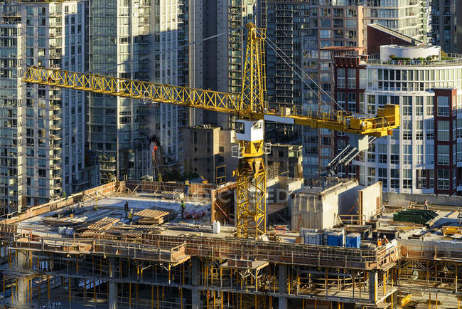 Vista de alto ángulo de la grúa en el sitio de construcción con rascacielos alrededor en Vancouver, Canadá - foto de stock