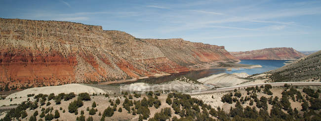 Estrada ao longo do lago e formações rochosas na paisagem do deserto — Fotografia de Stock