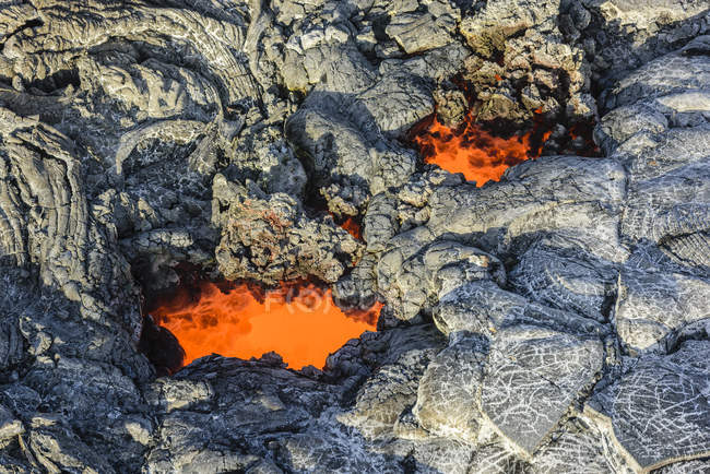 Molten lava glowing near dried lava on rocks of Big Island, Hawaii, USA — Stock Photo