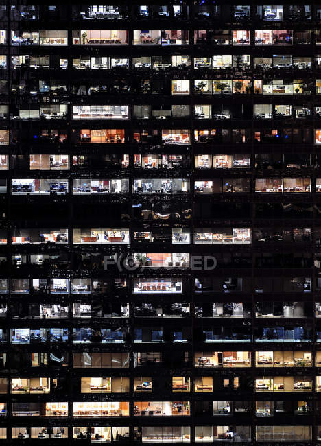 Marco completo de ventanas del edificio del rascacielos en la noche - foto de stock