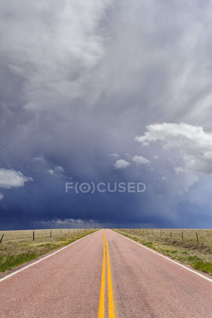 Nubes de tormenta sobre carretera abierta, Rush, Colorado, Estados Unidos - foto de stock
