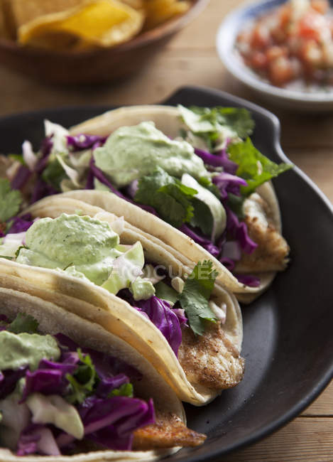 Gros plan de taco avec assiette de poisson, chou et légumes — Photo de stock