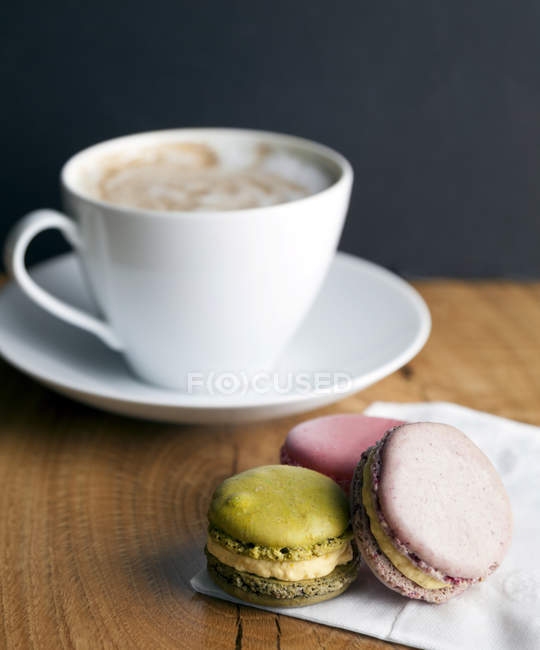 Primo piano dei biscotti al macaron e della tazza di caffè sul tavolo — Foto stock