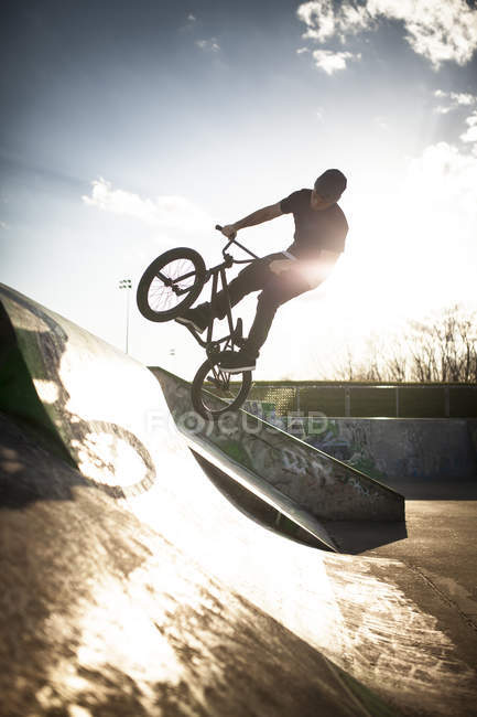 Caucasian man riding BMX bicycle at skate park — Stock Photo