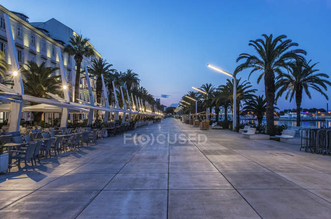 Promenade, Gebäude und Bürgersteig in der Abenddämmerung, geteilt, Kroatien — Stockfoto