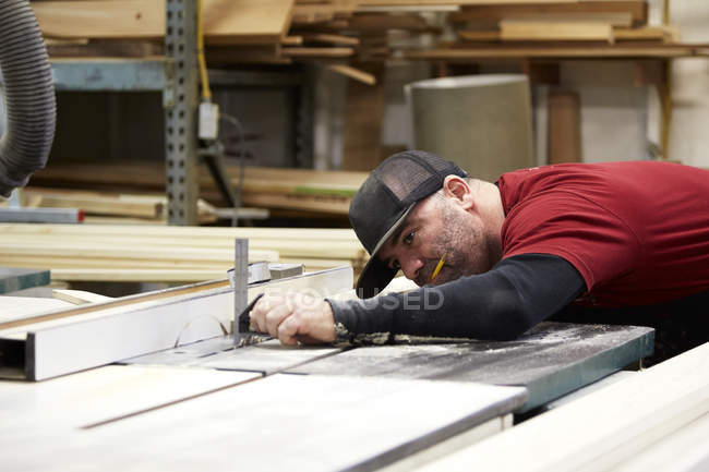 Tischler setzt Tischsäge im Werkstattinnenraum ein — Stockfoto