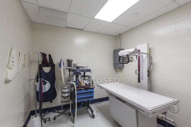 Mesa de examen y equipo de rayos X en hospital de animales - foto de stock