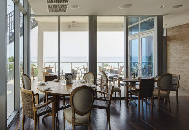 Порожні столи в розкішному ресторані за скляними стінами і вікнами — стокове фото