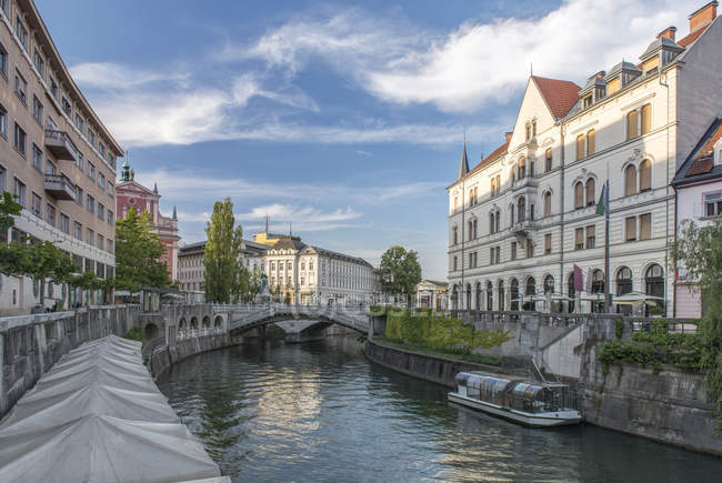 Buildings and pedestrian bridge over urban canal, Ljubljana, Central Slovenia, Slovenia — Stock Photo
