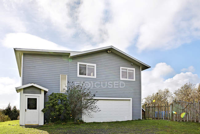 Casa di periferia su prato verde sotto cielo nuvoloso, Grayland, Washington, Stati Uniti d'America — Foto stock