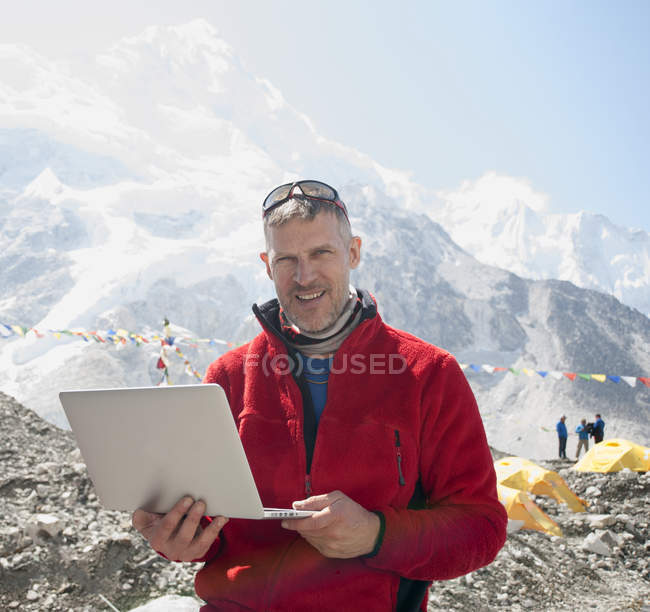 Человек с ноутбуком в заснеженных горах, базовый лагерь Эверест, Непал, Азия — стоковое фото