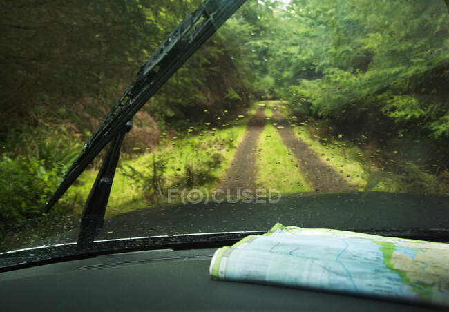 Windshield wipers and map on dashboard of car — Stock Photo