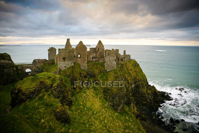 Castle ruins on cliffs at ocean in sunlight, Antrim, County Antrim, Northern Ireland — Stock Photo