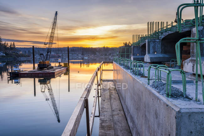 Reflexion von Brückenbau und Sonnenuntergang in stiller Bucht, Gig Harbor, Washington, USA — Stockfoto