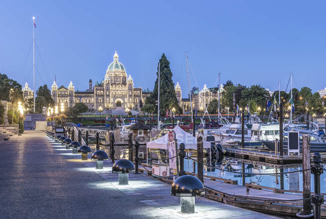 Edificio del Parlamento y puerto iluminado al amanecer, Victoria, Columbia Británica, Canadá - foto de stock