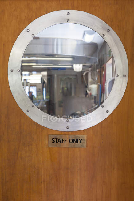 Porthole above Staff Only sign on ship door — Stock Photo