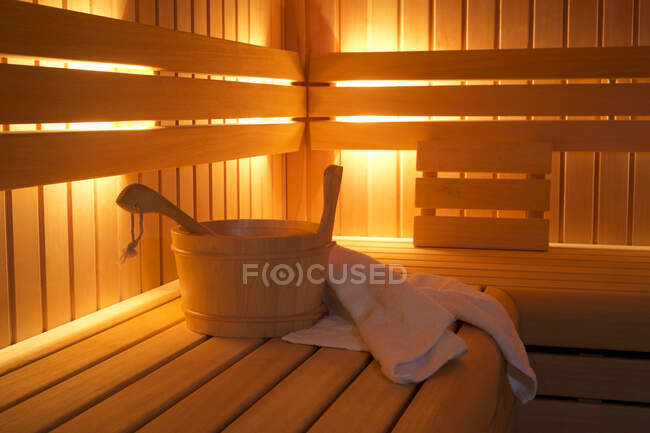 Bucket and towels in sauna — Stock Photo