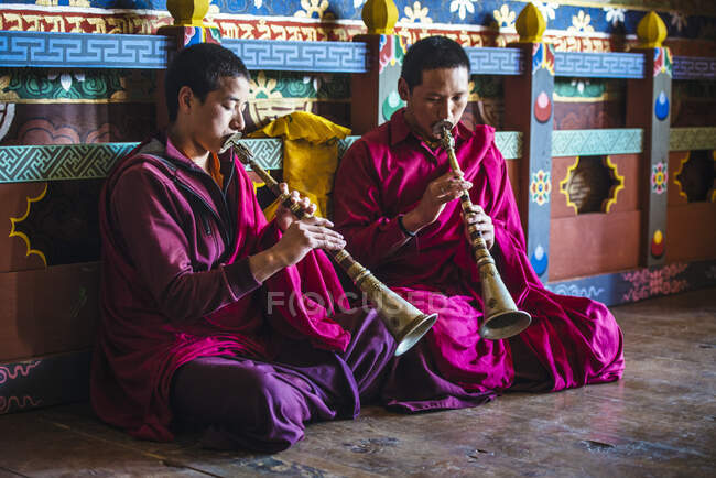 Monjes asiáticos tocando instrumentos en el suelo del templo - foto de stock