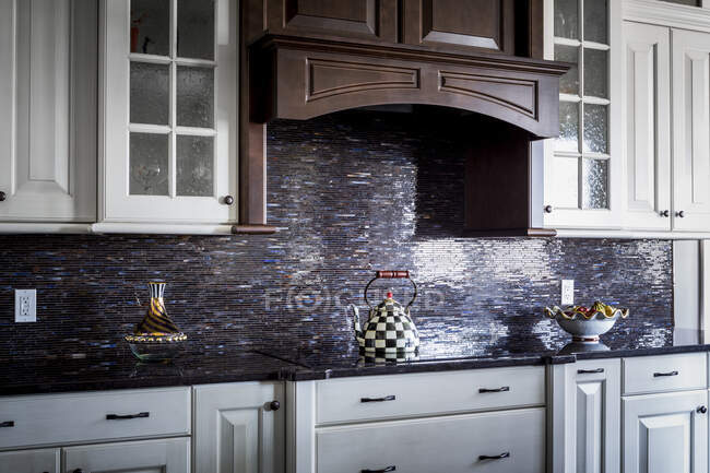 Checkered teapot on stove in kitchen — Stock Photo