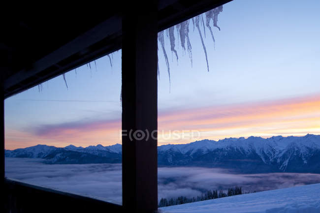 Cielo colorido sobre montañas cubiertas de nieve en un paisaje remoto - foto de stock
