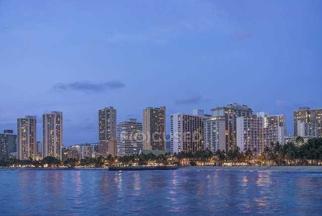 Skyline iluminado de la ciudad en el paseo marítimo, Honolulu, Hawaii, Estados Unidos - foto de stock