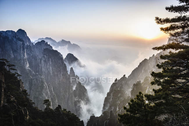Nevoeiro rolando sobre montanhas rochosas, Huangshan, Anhui, China — Fotografia de Stock