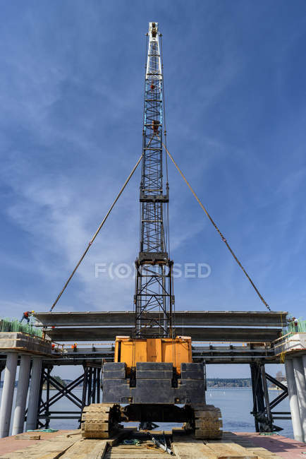 Vista de ángulo bajo de la construcción de grúas y puentes, Gig Harbor, Washington, EE.UU. - foto de stock