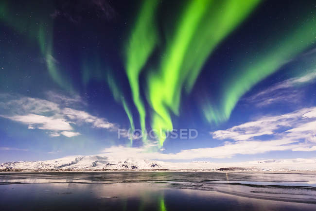 Luces boreales reflejándose en un río aún remoto en la laguna de Jokulsarlon, Islandia - foto de stock