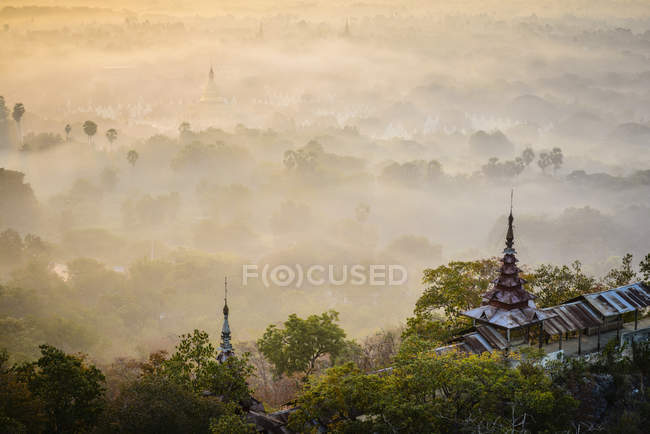 Nebbia sulle cime degli alberi e sulle torri del tempio, Mandalay, Myanmar — Foto stock
