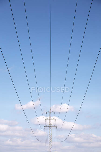 Низький кут огляду ліній електропередач під блакитним небом — стокове фото