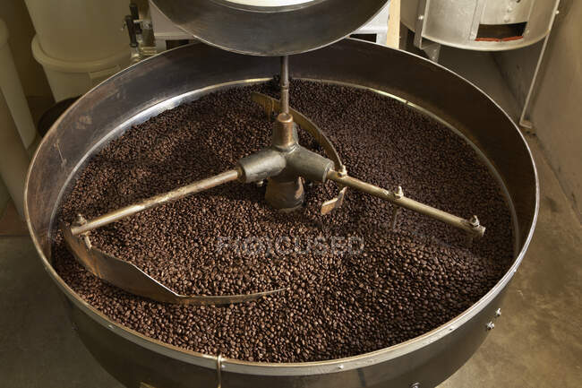 Frijoles de café tostados en hervidor industrial - foto de stock