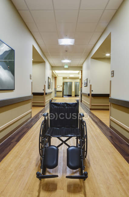 Empty wheelchair in assisted living facility hallway — Stock Photo