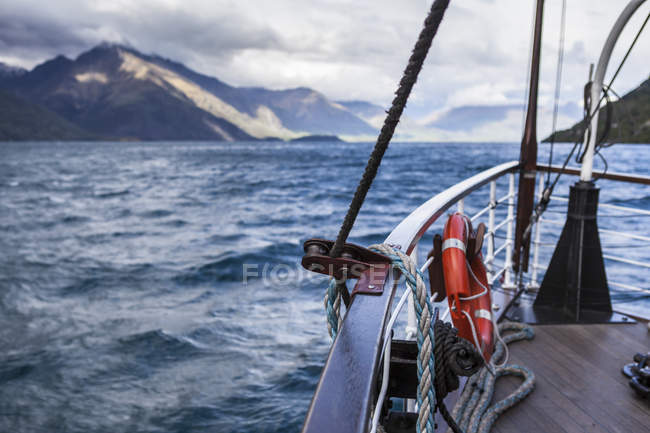 Лодка на озере у гор в Квинстоуне, Новая Зеландия — стоковое фото
