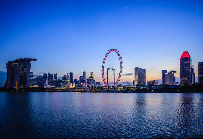 Ville de Singapour skyline avec ferris roue et bâtiments modernes sous le soleil couchant ciel, Singapour, Singapour — Photo de stock