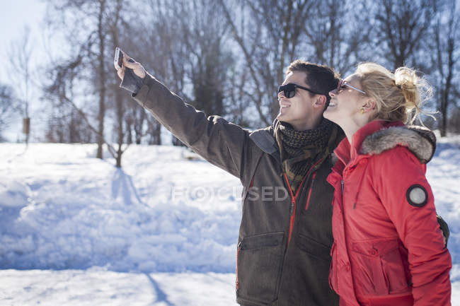 Young couple taking selfie in winter park — Stock Photo