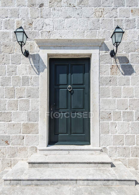 Front door and lamps of stone building — Stock Photo