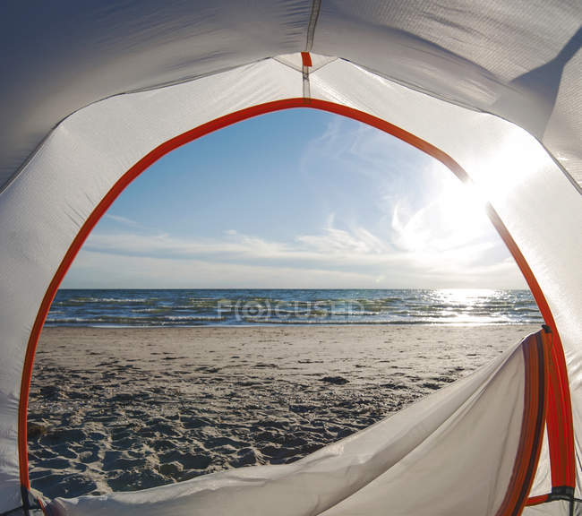 Abra a porta da barraca de acampamento na praia com backlit — Fotografia de Stock