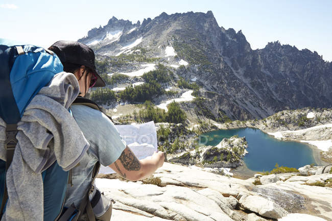 Female hiker reading map on hilltop — Stock Photo