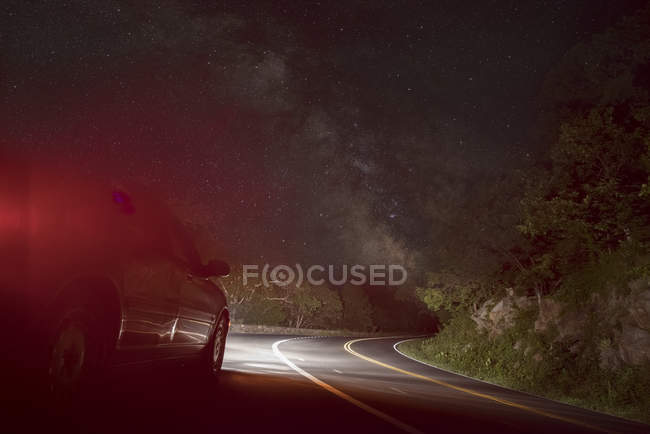 Auto su strada tortuosa sotto il cielo stellato — Foto stock