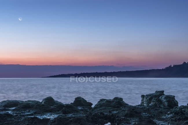 Sonnenaufgang über Felsformationen am malerischen Strand — Stockfoto